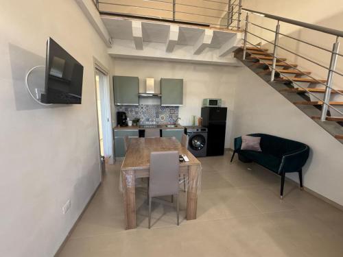a living room with a dining room table and a staircase at Sole di Sicilia in Locogrande