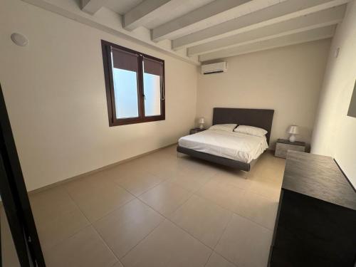 a bedroom with a bed and a window at Sole di Sicilia in Locogrande
