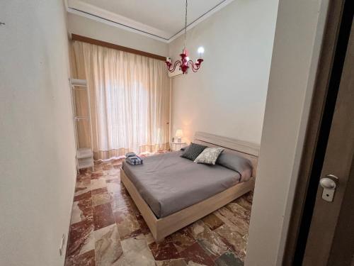 a bedroom with a bed and a large window at Pompeano House in Mazara del Vallo