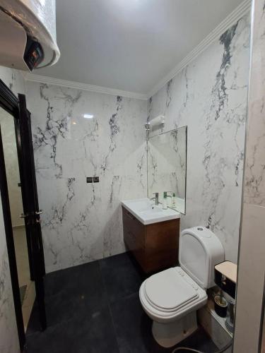 a white bathroom with a toilet and a sink at Appartement vu sur Mer in Mohammedia