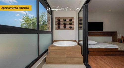a bathroom with a tub and a bed and a window at WANDERLUST Experience Hotel in Campos do Jordão