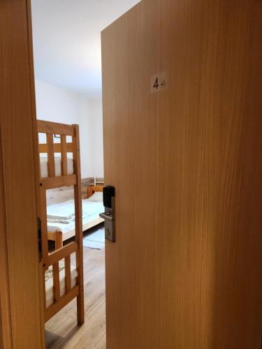 ajar door to a bedroom with a bunk bed at REKLINIEC in Myślenice