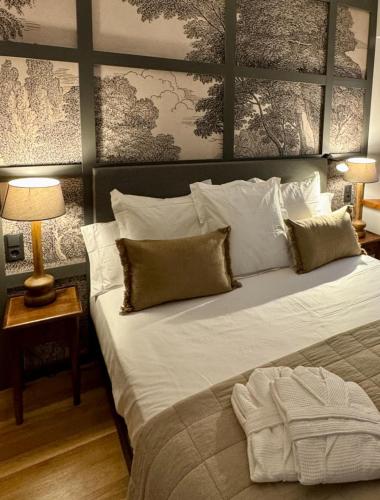 a bedroom with a large bed with white sheets and pillows at Hotel Quinta Solera in Oviedo