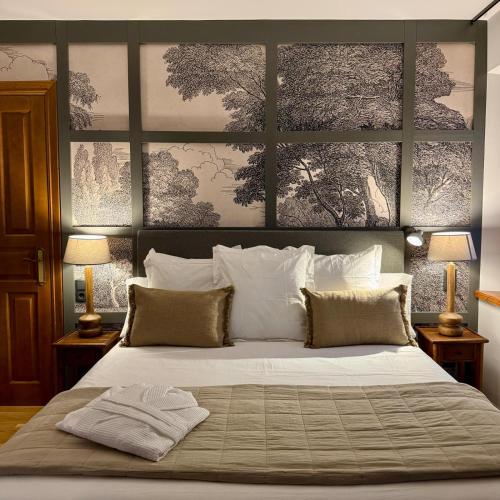 a bedroom with a large white bed with two lamps at Hotel Quinta Solera in Oviedo