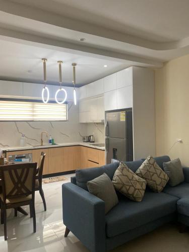 a living room with a blue couch and a kitchen at Allman luxurious one bedroom near beaches in Llandovery