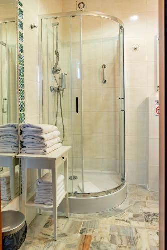 a shower in a bathroom with towels on a table at Masuria Hotel & SPA in Łukta