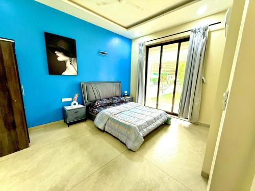 a blue bedroom with a bed and a window at White Forest villa in Lonavala