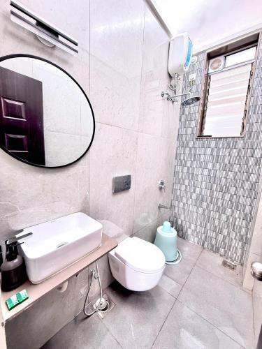 a bathroom with a sink and a toilet and a mirror at White Forest villa in Lonavala