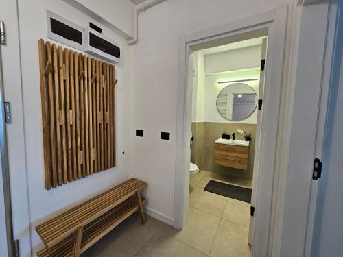 ein Badezimmer mit Toilette und Holzbank in der Unterkunft Alezzi Odyssey Mamaia Nord II - Parcare Inclusa in Mamaia Nord – Năvodari