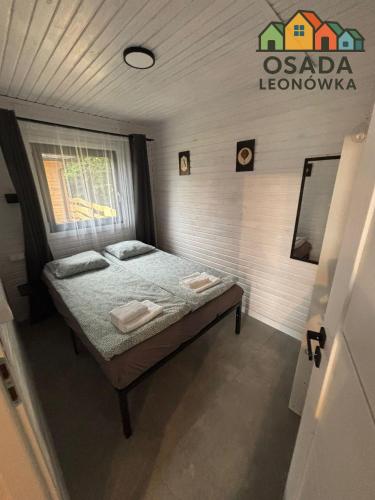 LeonówにあるOsada Leonówkaの部屋にベッドが置かれた小さな寝室