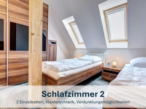 two beds in a bedroom with two windows at Peenemünde, Panoramawohnung in Peenemünde