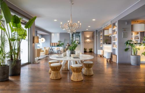 a living room with a white table and stools at Excelsior Hotel, SPA & Lido - Preferred Hotels & Resorts in Pesaro