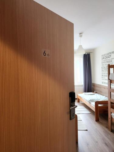 a room with a wooden door with a bed at REKLINIEC in Myślenice