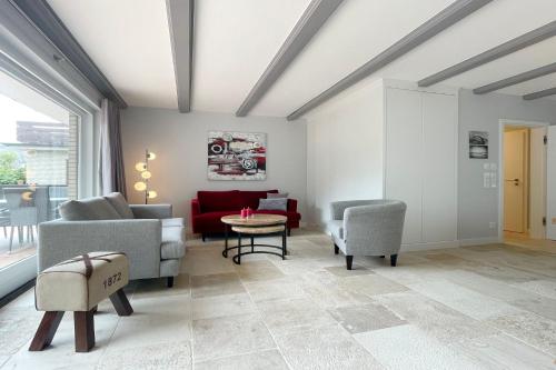 un salon avec un canapé rouge et des chaises dans l'établissement Ferienwohnung Goede Tiid, à Tinnum