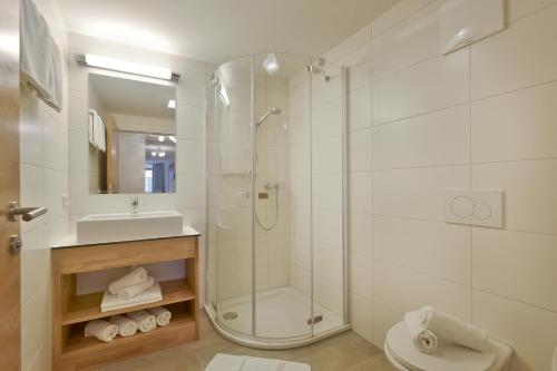 een badkamer met douche, toilet en wastafel bij Jaegerhaus Appartements in Hopfgarten im Brixental