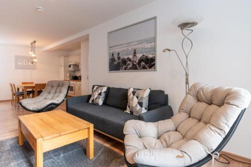 a living room with a couch and chairs and a table at Ferienwohnung 11 Villa Eden in Binz