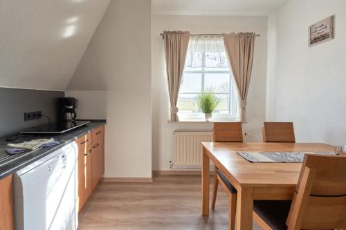 a kitchen with a wooden table and a dining room at Vosskuhl Kabuff Twee in Südermarsch
