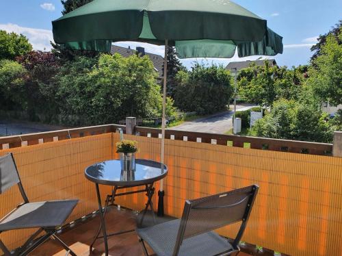 a table and chairs with an umbrella on a fence at Kleinod am Kurpark in Bad Zwesten