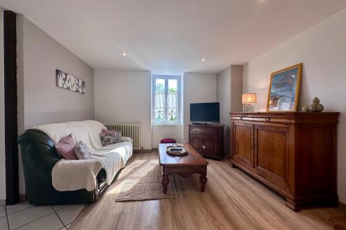 ein Wohnzimmer mit Sofa und Fernseher in der Unterkunft Maison de Perpezac - Jardin & Clim - 7 personnes - Perpezac-le-Noir in Perpezac-le-Noir