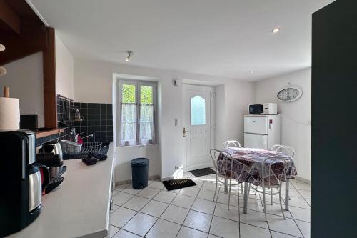 eine Küche mit Tisch und Stühlen in einem Zimmer in der Unterkunft Maison de Perpezac - Jardin & Clim - 7 personnes - Perpezac-le-Noir in Perpezac-le-Noir