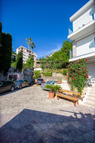 a building with a bench and flowers in a parking lot at ACIKA apartments in Rafailovici