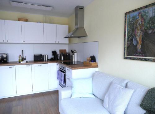 a living room with a couch and a kitchen at Ferienhaus SeePromenade in Krakow am See