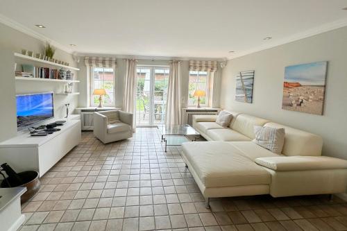 ティンヌムにあるFerienhaus Gartenweg 3bのソファとテレビのあるリビングルーム