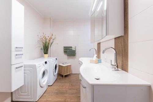a white laundry room with a washer and dryer at Ferienwohnungen zum Lengener Meer 35527 - nur für Urlaubsgäste in Uplengen