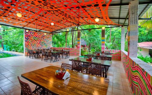 a restaurant with tables and chairs and a patio at La Roca Inn in Assagao
