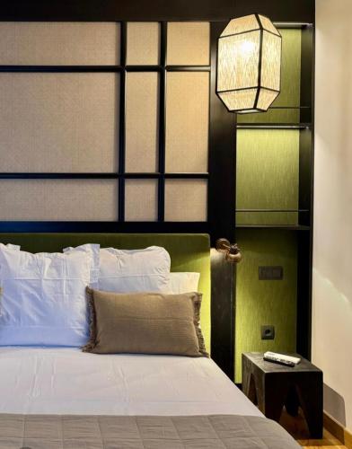 a bedroom with a bed with a black and green headboard at Hotel Quinta Solera in Oviedo