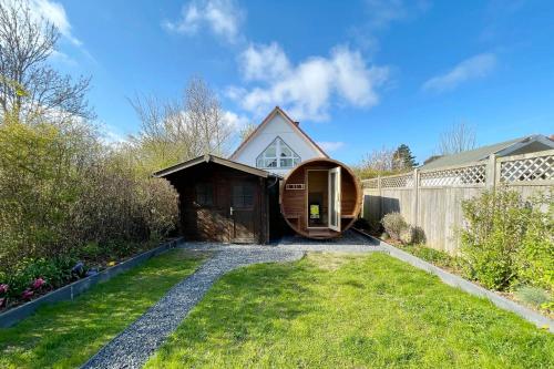 une petite maison avec une porte en bois dans une cour dans l'établissement Ferienhaus Erika, à Tinnum