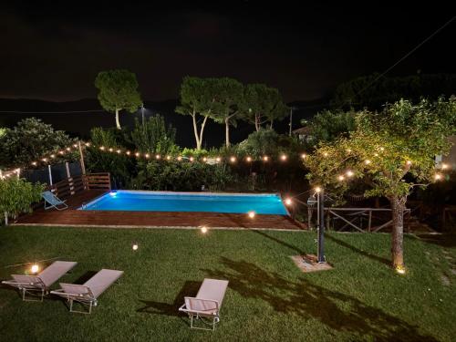 a backyard at night with a swimming pool and lights at Ligo in Villanova dʼAlbenga