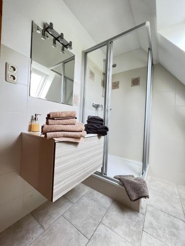 a bathroom with a shower and a mirror and towels at Strandperle in List