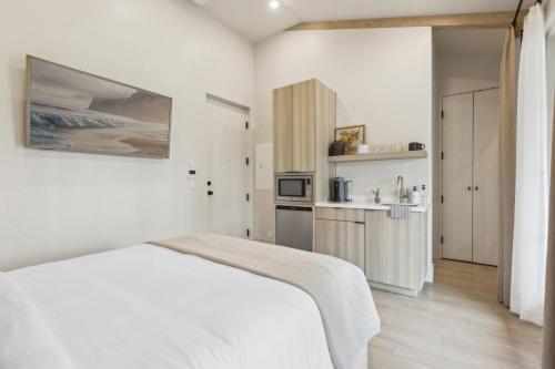 a white room with a bed and a kitchen at Casa Riviera - Boutique Suites in Downtown Santa Barbara in Santa Barbara