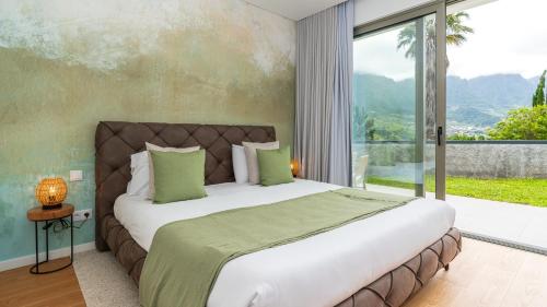 a bedroom with a large bed and a large window at Elysium by LovelyStay in São Vicente