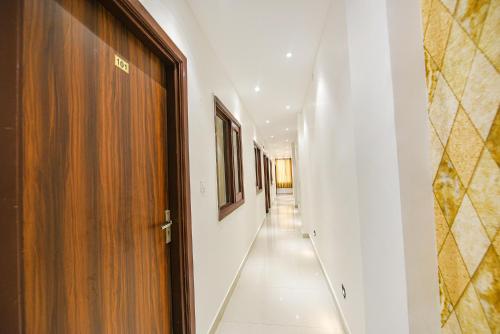 a hallway with white walls and a wooden door at SOLACE INN near GOLDEN temple in Amritsar