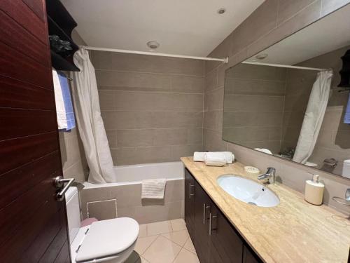 a bathroom with a sink and a toilet and a tub at Appartement Bouznika Bay Golf Beach in Bouznika