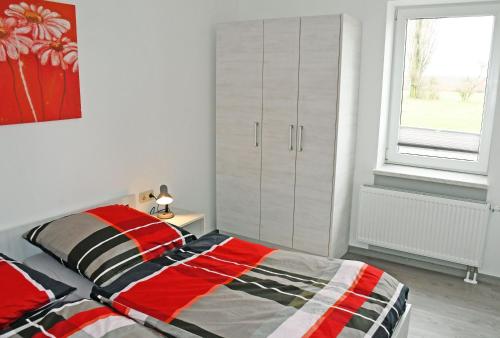 a bedroom with a bed and a large window at Ferienwohnungen Udars auf Rügen in Udars