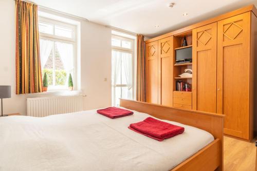 a bedroom with a bed with two red towels on it at Ferienwohnung 14 Villa Eden in Binz