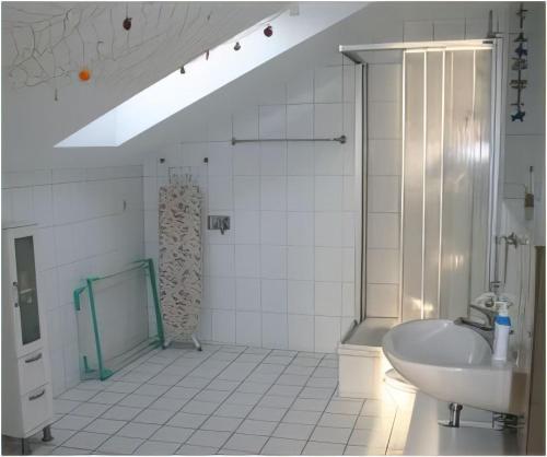 a white bathroom with a shower and a sink at Ferienwohnung - Orther Hafenblick in Orth