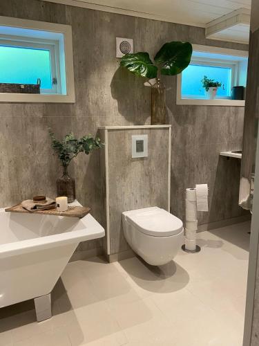 a bathroom with a toilet and a sink at Enebolig på Nesbrygga 