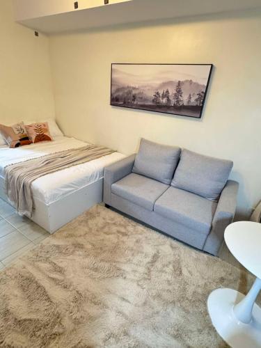 a living room with a bed and a couch at Queen's Escape in Manila