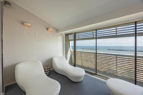 a room with two white chairs and a large window at Excelsior Hotel, SPA & Lido - Preferred Hotels & Resorts in Pesaro