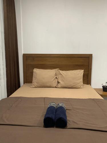 a bed with a pair of blue shoes on it at Paddy View Hostel in Banyuwangi