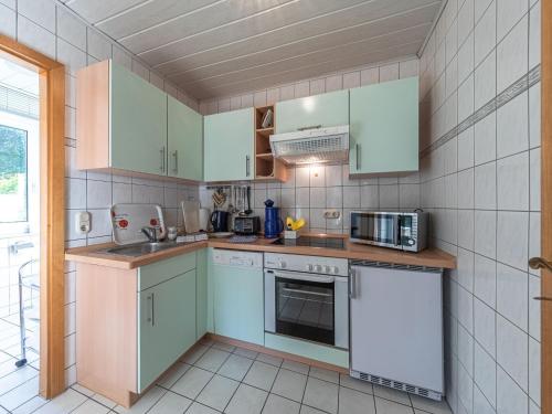 a kitchen with white and green cabinets and appliances at Groot Huus in Lärz