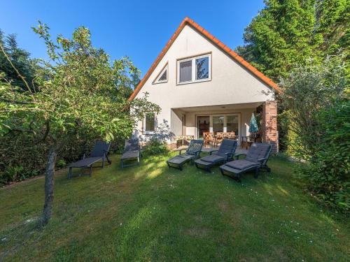 a group of chairs sitting on a lawn in front of a house at Groot Huus in Lärz