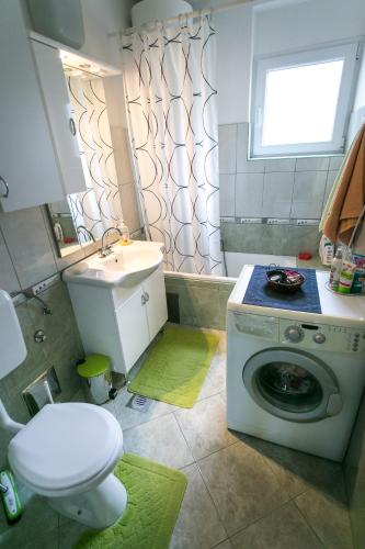a bathroom with a washing machine and a sink at Apartman Snjeska in Buzet