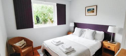 una camera da letto con un letto, una finestra e una sedia di Gorton House & Orchard Cottages a Roslin