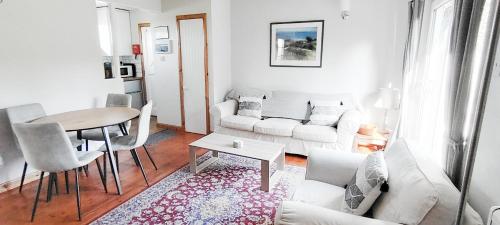 a living room with a white couch and a table at Orchard Cottages at Gorton House in Roslin