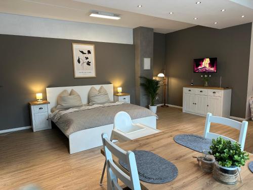 a bedroom with a bed and a table and chairs at Ferienwohnung auf dem Land in Grethem